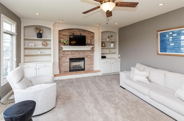 12602 Winston Ave, Urbandale, IA 50323 - carpeted living area with ceiling fan, a stone fireplace, built in shelves, and recessed lighting