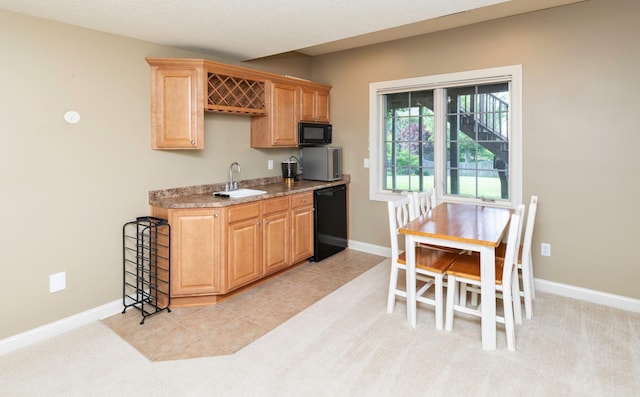 12602 Winston Ave, Urbandale, IA 50323 - kitchen featuring black appliances, light brown cabinetry, and light countertops