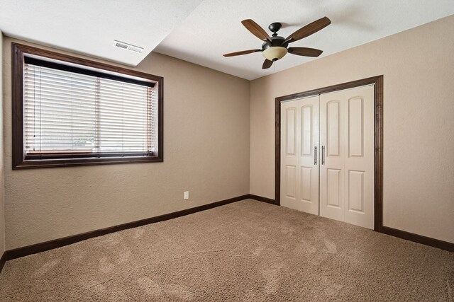 300 NW Sunset Ln, Grimes, IA 50111 - unfurnished bedroom featuring carpet floors, a closet, and a ceiling fan