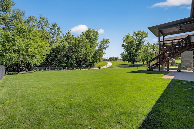 300 NW Sunset Ln, Grimes, IA 50111 - view of yard with stairway, a ceiling fan, and a patio