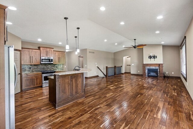 300 NW Sunset Ln, Grimes, IA 50111 - kitchen featuring vaulted ceiling, dark wood-type flooring, a ceiling fan, appliances with stainless steel finishes, and open floor plan