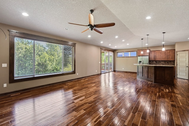 300 NW Sunset Ln, Grimes, IA 50111 - unfurnished living room featuring a ceiling fan, dark wood-style flooring, a textured ceiling, and recessed lighting
