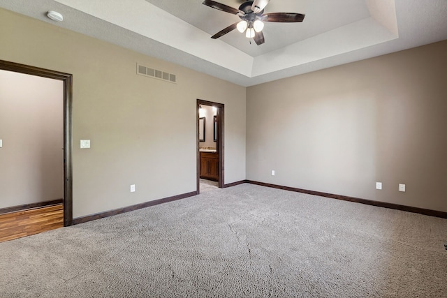 300 NW Sunset Ln, Grimes, IA 50111 - unfurnished bedroom with light carpet, a raised ceiling, ensuite bath, and ceiling fan