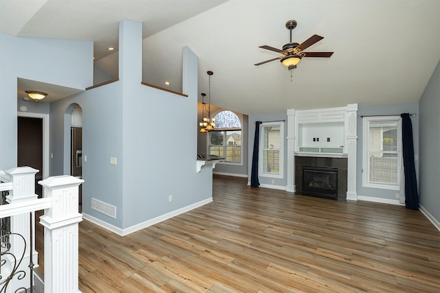 1736 Ashwood Dr SW, Altoona, IA 50009 - unfurnished living room with a ceiling fan, arched walkways, a fireplace, wood finished floors, and high vaulted ceiling