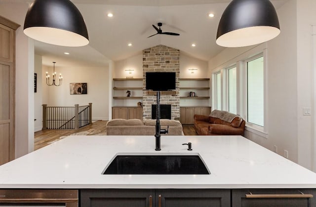 1103 170th St, Dexter, IA 50070 - kitchen with open floor plan, lofted ceiling, a stone fireplace, a center island with sink, and light wood-style flooring