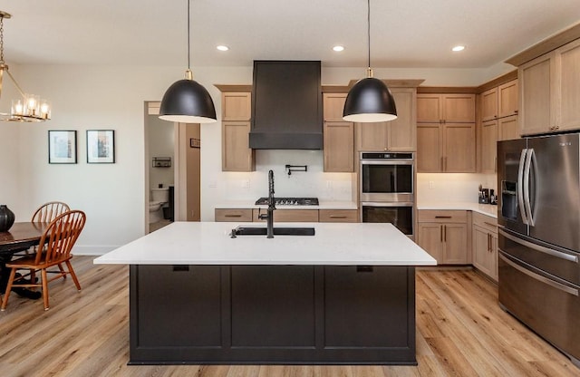 1103 170th St, Dexter, IA 50070 - kitchen featuring appliances with stainless steel finishes, custom range hood, light countertops, light wood-type flooring, and a chandelier
