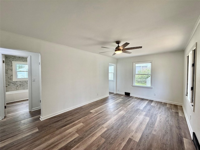2000 E 21st St, Des Moines, IA 50317 - unfurnished room featuring healthy amount of natural light, a ceiling fan, dark wood finished floors, and crown molding