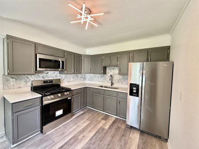 2000 E 21st St, Des Moines, IA 50317 - kitchen with stainless steel appliances, light countertops, light wood-style floors, decorative backsplash, and crown molding