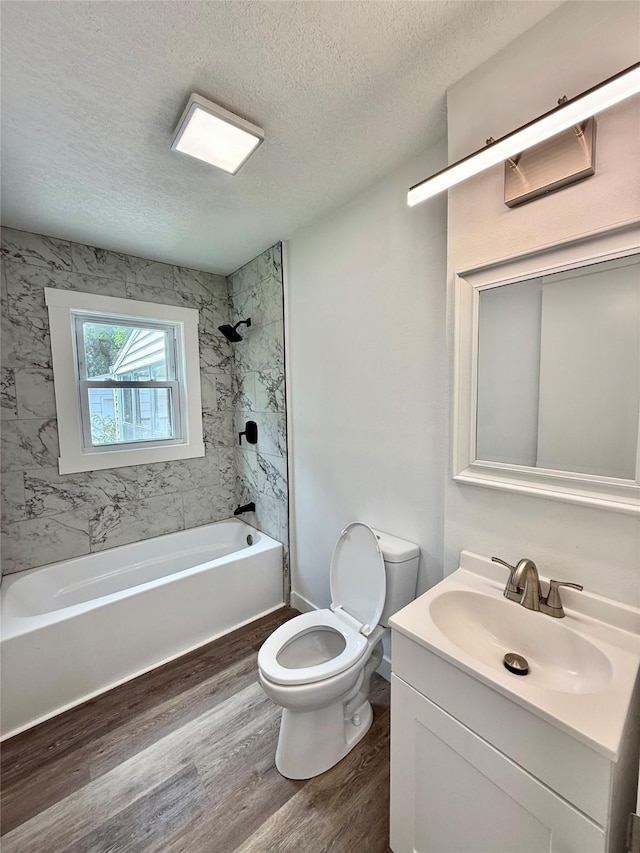 2000 E 21st St, Des Moines, IA 50317 - bathroom with wood finished floors, vanity, a textured ceiling, and bathing tub / shower combination