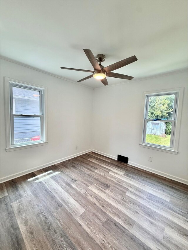 2000 E 21st St, Des Moines, IA 50317 - unfurnished room with plenty of natural light, wood finished floors, ceiling fan, and crown molding