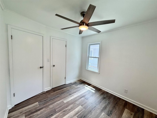 2000 E 21st St, Des Moines, IA 50317 - unfurnished bedroom with crown molding, dark wood-type flooring, and ceiling fan
