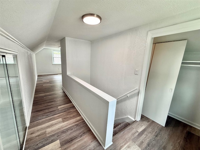 2000 E 21st St, Des Moines, IA 50317 - corridor featuring a textured ceiling, wood finished floors, lofted ceiling, and an upstairs landing