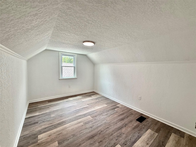 2000 E 21st St, Des Moines, IA 50317 - additional living space with a textured ceiling, wood finished floors, a textured wall, and lofted ceiling