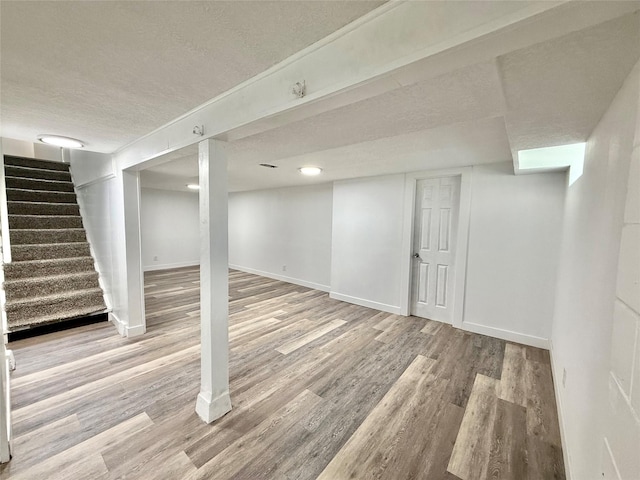 2000 E 21st St, Des Moines, IA 50317 - finished basement featuring wood finished floors, a textured ceiling, and stairway