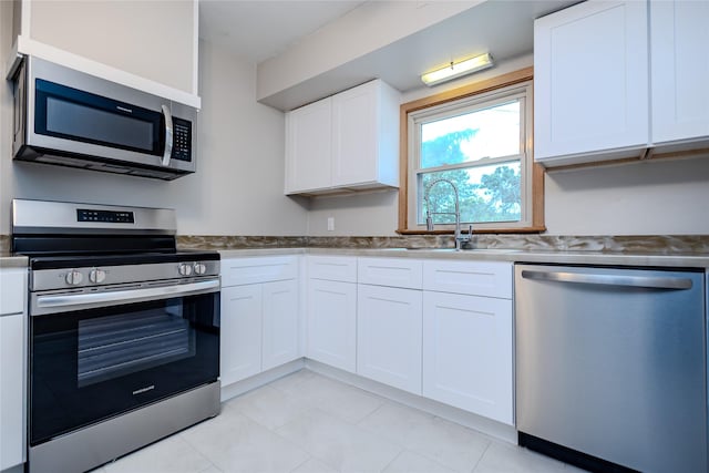 4008 Douglas Ave, Des Moines, IA 50310 - kitchen with appliances with stainless steel finishes, white cabinets, and light tile patterned flooring