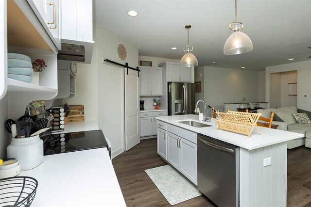 1302 S L Ct, Indianola, IA 50125 - kitchen featuring appliances with stainless steel finishes, a barn door, dark wood finished floors, open floor plan, and light countertops