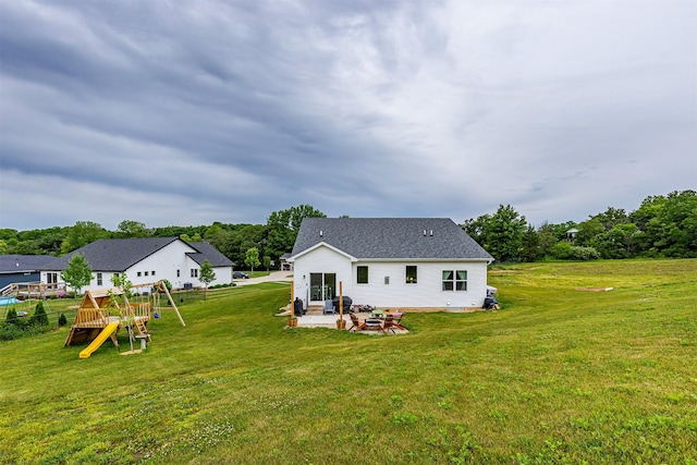 1302 S L Ct, Indianola, IA 50125 - rear view of house with a playground, a yard, a patio area, a shingled roof, and view of scattered trees