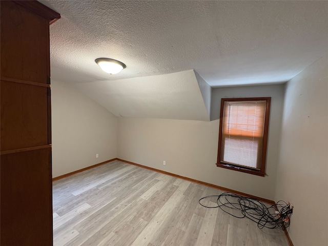3206 62nd St, Des Moines, IA 50322 - bonus room featuring light wood-style flooring, a textured ceiling, and lofted ceiling
