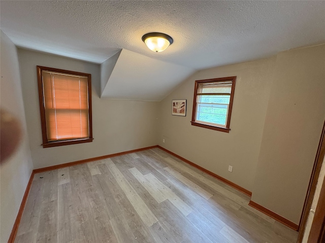 3206 62nd St, Des Moines, IA 50322 - additional living space with light wood finished floors, a textured ceiling, and lofted ceiling