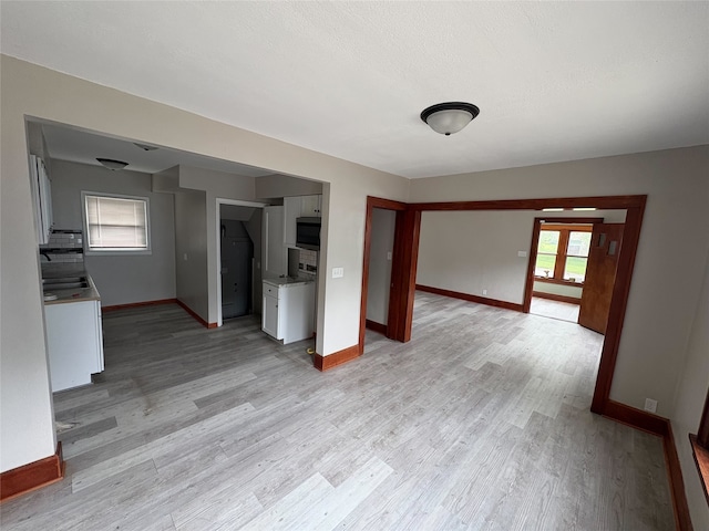3206 62nd St, Des Moines, IA 50322 - unfurnished living room featuring baseboards and light wood-type flooring