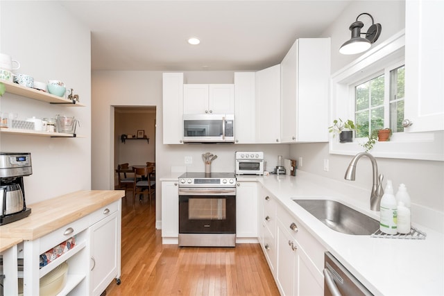 5617 Grand Ave, Des Moines, IA 50312 - kitchen featuring appliances with stainless steel finishes, open shelves, white cabinets, and recessed lighting