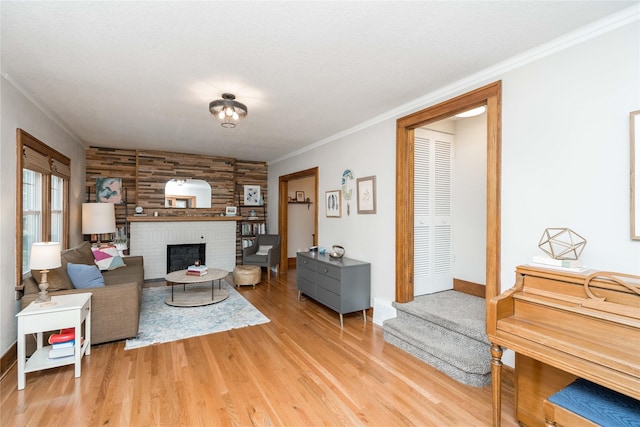 5617 Grand Ave, Des Moines, IA 50312 - living room with light wood-type flooring, a brick fireplace, and crown molding