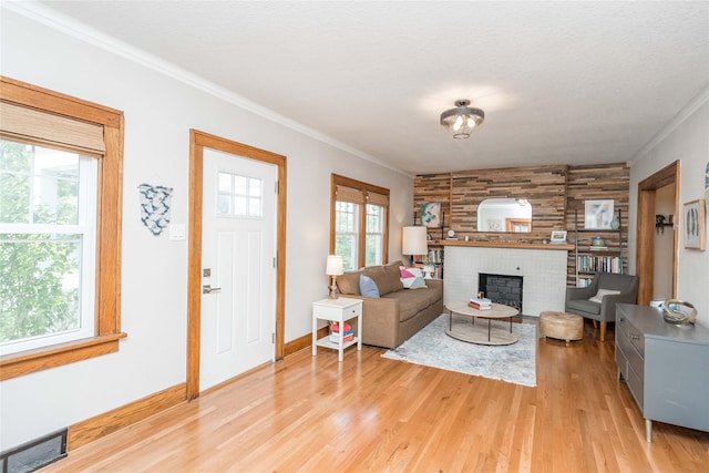 5617 Grand Ave, Des Moines, IA 50312 - living area with crown molding, light wood-style flooring, and a fireplace
