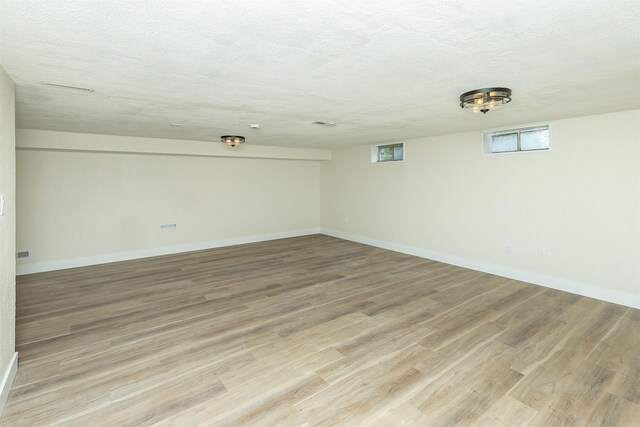 401 NE Harvey St, Grimes, IA 50111 - spare room featuring light wood-type flooring and a textured ceiling
