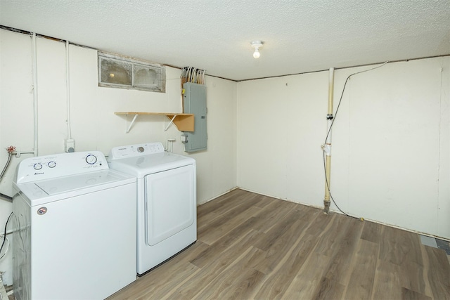401 NE Harvey St, Grimes, IA 50111 - laundry room with electric panel, washing machine and dryer, light wood-style floors, and a textured ceiling