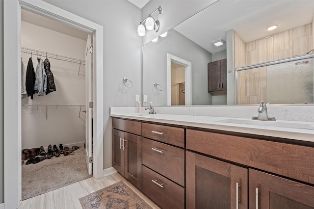 5397 Brook View Ave, Des Moines, IA 50317 - full bathroom featuring double vanity, a walk in closet, and an enclosed shower