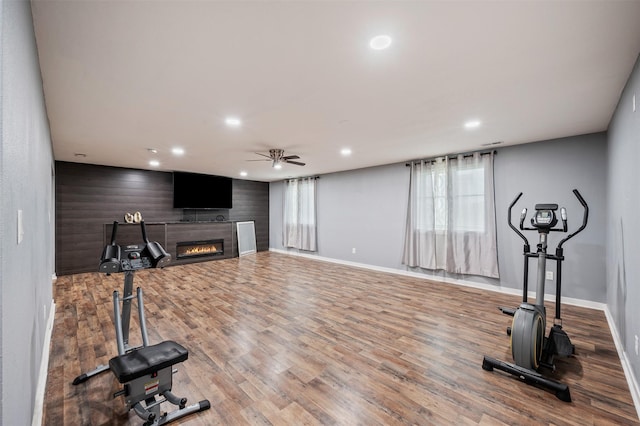 5397 Brook View Ave, Des Moines, IA 50317 - workout area with a ceiling fan, wood finished floors, a glass covered fireplace, recessed lighting, and plenty of natural light