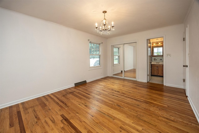 2217 Meadow Ln, West Des Moines, IA 50265 - empty room featuring a chandelier, crown molding, and light wood-style flooring