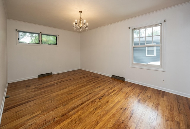 2217 Meadow Ln, West Des Moines, IA 50265 - unfurnished room with a chandelier, plenty of natural light, ornamental molding, and wood finished floors