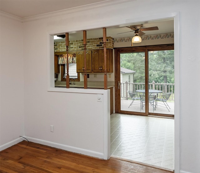 2217 Meadow Ln, West Des Moines, IA 50265 - kitchen featuring ceiling fan, crown molding, wood finished floors, and brown cabinetry