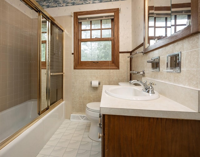 2217 Meadow Ln, West Des Moines, IA 50265 - bathroom featuring plenty of natural light, vanity, combined bath / shower with glass door, and tile walls