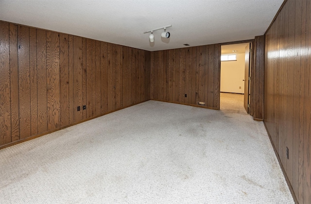 2217 Meadow Ln, West Des Moines, IA 50265 - unfurnished room featuring light carpet, wood walls, track lighting, and a textured ceiling