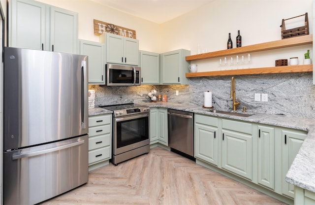 400 E Locust St Unit 102, Des Moines, IA 50309 - kitchen featuring appliances with stainless steel finishes, open shelves, decorative backsplash, and green cabinetry