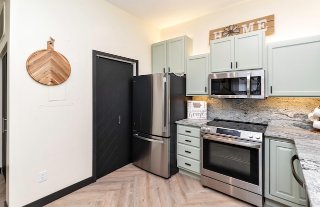 400 E Locust St Unit 102, Des Moines, IA 50309 - kitchen featuring stainless steel appliances, backsplash, and light stone countertops