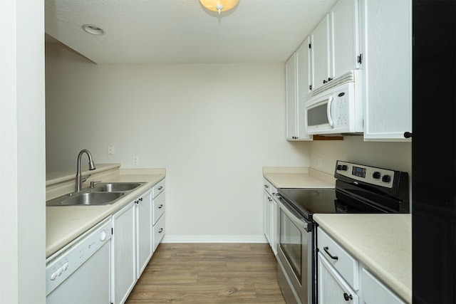 2240 Hart Ave Unit 4, Des Moines, IA 50320 - kitchen featuring white appliances, light wood finished floors, white cabinets, and light countertops