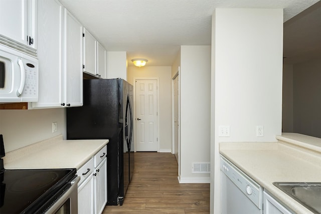 2240 Hart Ave Unit 4, Des Moines, IA 50320 - kitchen featuring white appliances, wood finished floors, white cabinetry, and light countertops