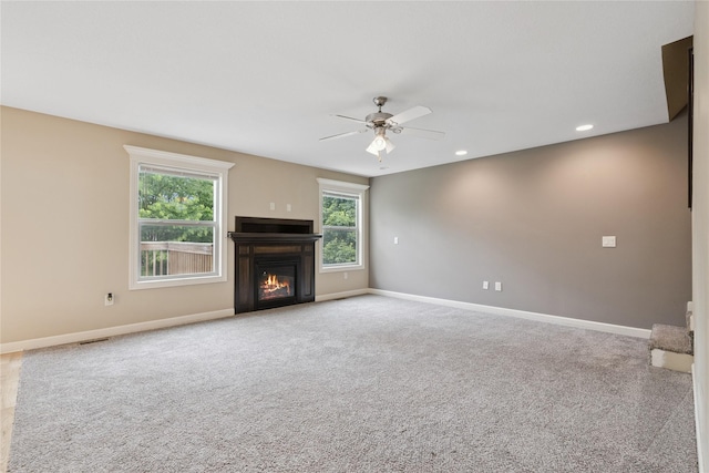 16205 Monroe Ct, Urbandale, IA 50323 - unfurnished living room featuring ceiling fan, a glass covered fireplace, carpet floors, and recessed lighting