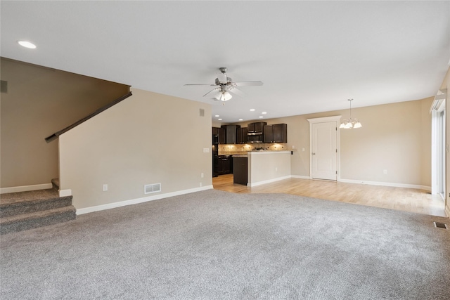 16205 Monroe Ct, Urbandale, IA 50323 - unfurnished living room featuring light carpet, a ceiling fan, a chandelier, recessed lighting, and stairway