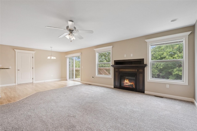 16205 Monroe Ct, Urbandale, IA 50323 - unfurnished living room with a glass covered fireplace, carpet, a chandelier, and a ceiling fan