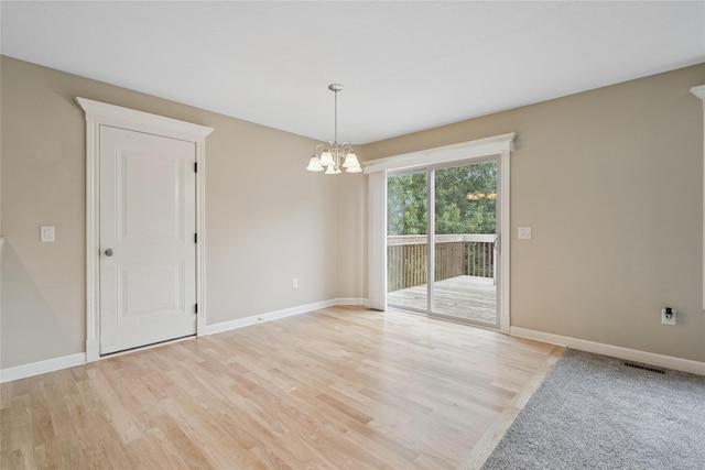 16205 Monroe Ct, Urbandale, IA 50323 - spare room with a chandelier and light wood-type flooring