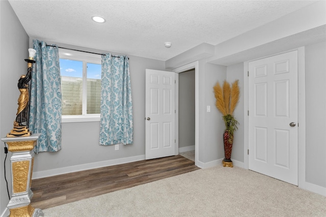 4669 171st St, Urbandale, IA 50323 - unfurnished bedroom with a textured ceiling, recessed lighting, carpet floors, and wood finished floors