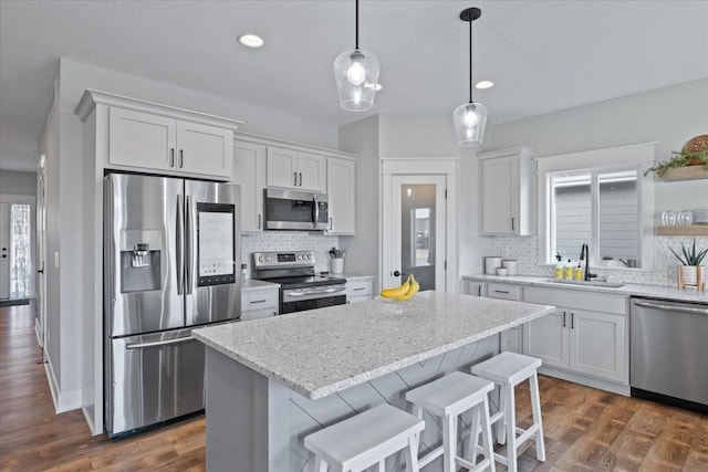 519 Alpha St NW, Bondurant, IA 50035 - kitchen featuring stainless steel appliances, decorative backsplash, white cabinets, and recessed lighting