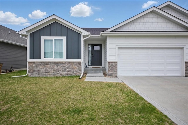 519 Alpha St NW, Bondurant, IA 50035 - view of front of house with stone siding, concrete driveway, and a front yard