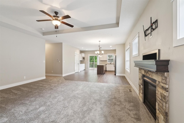 14335 Holcomb Ave, Urbandale, IA 50323 - unfurnished living room featuring a stone fireplace, a chandelier, carpet, ceiling fan, and recessed lighting