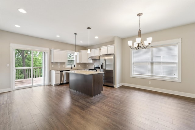 14335 Holcomb Ave, Urbandale, IA 50323 - kitchen featuring stainless steel appliances, under cabinet range hood, a chandelier, a center island, and white cabinets