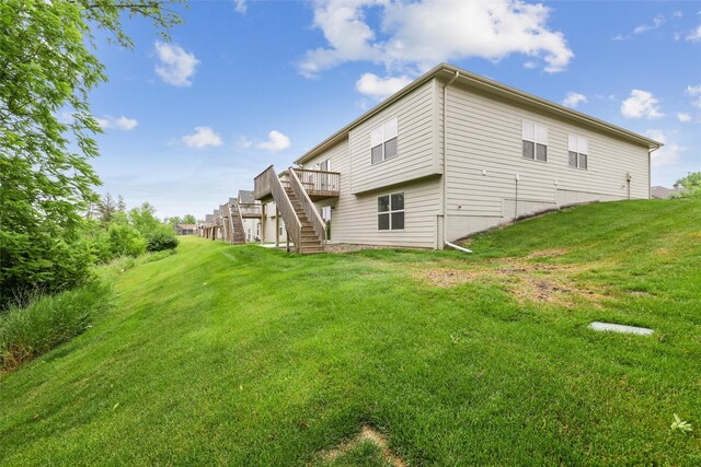 14335 Holcomb Ave, Urbandale, IA 50323 - back of house with stairway, a wooden deck, and a lawn
